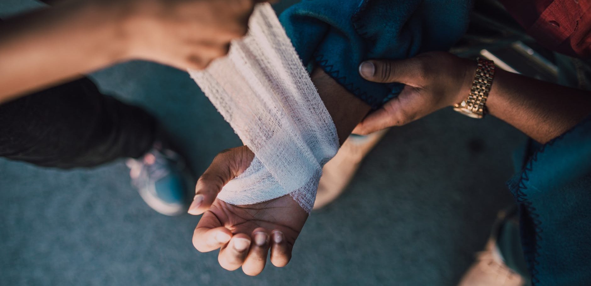 person putting bandage on another person s hand